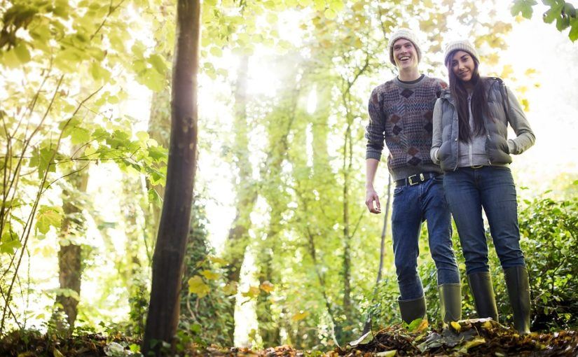 A young, happy couple hiking in the woods