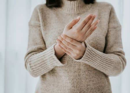 Woman rubbing her hands with arthritis pain