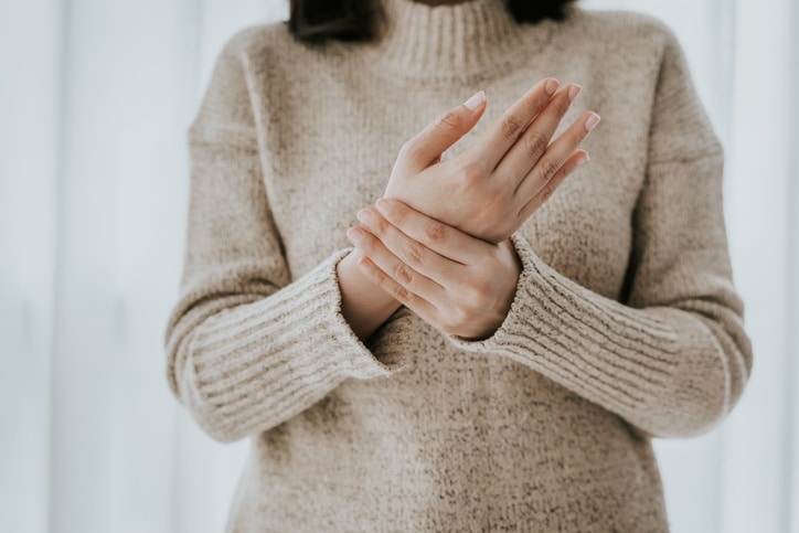 Woman rubbing her hands with arthritis pain