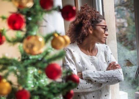 A woman looking out of a window as she struggles with her chronic pain