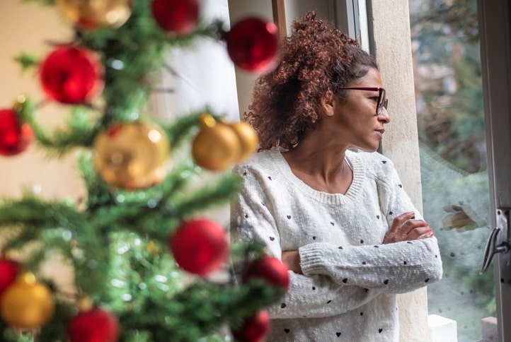 A woman looking out of a window as she struggles with her chronic pain