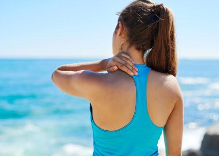 A young woman rubbing her shoulder pain