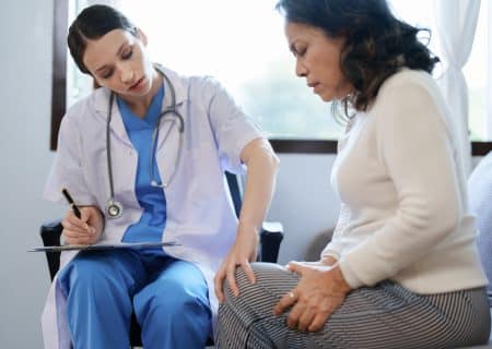 A doctor examining a patient’s knee.