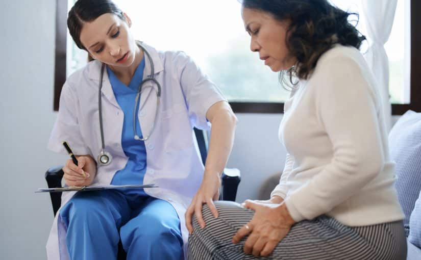 A doctor examining a patient’s knee.